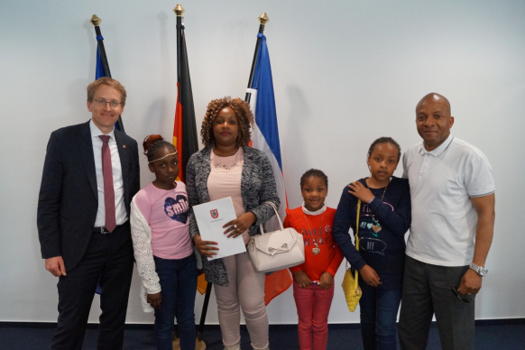Ministerpräsident Daniel Günther (l.) gratulierte Familie Ekwuruibe aus Kenia zur Einbürgerung
